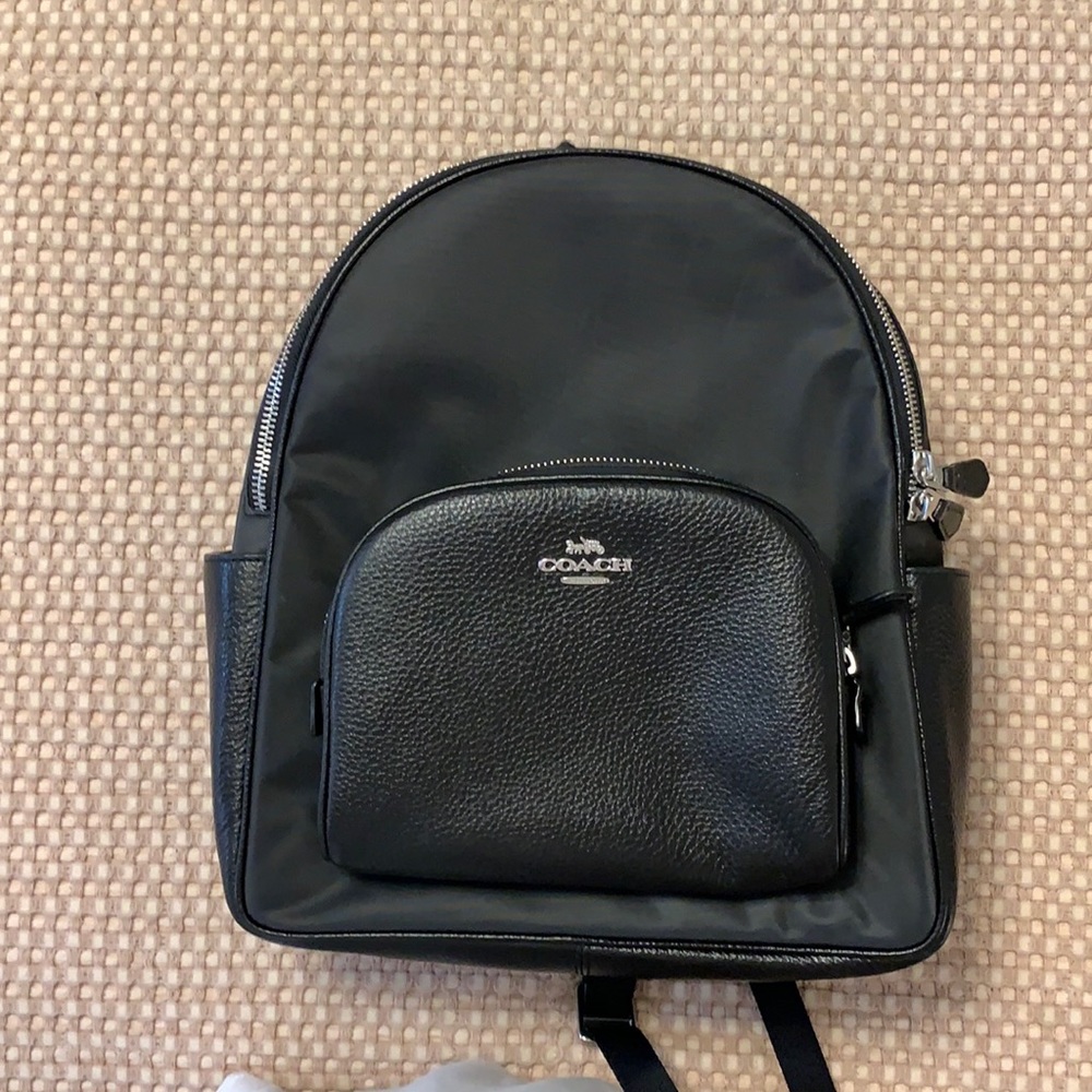 Used Coach backpack. Black. Nylon with leather trim. Light scratches on nylon.